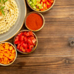 Home top view raw dough pasta formed with vegetables seasonings brown table dough raw food pasta meal